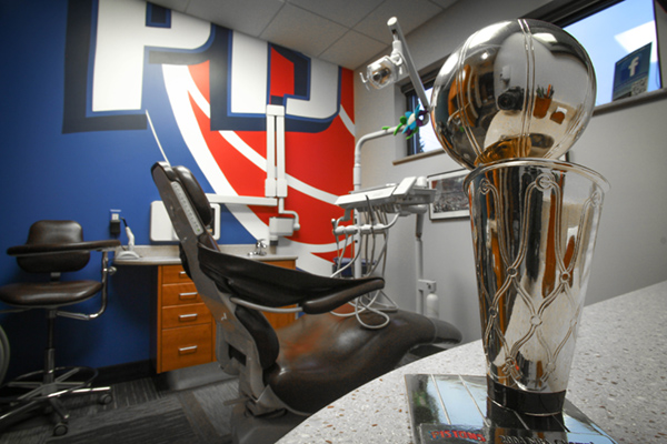 The image shows an office space with a trophy, a sports ball, and a chair in the foreground.