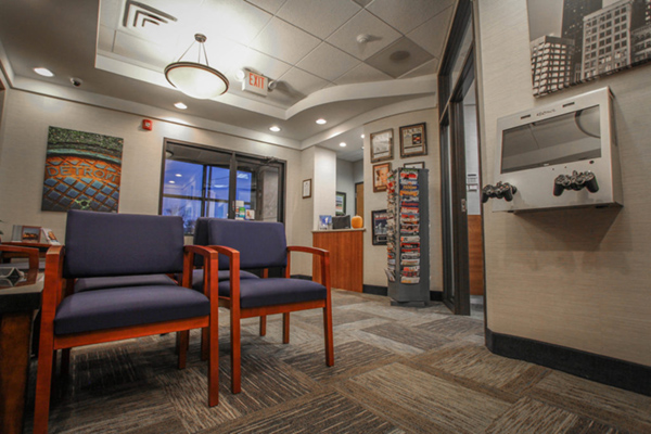 The image shows an interior space, likely a waiting room or lobby, with modern furniture and decor.