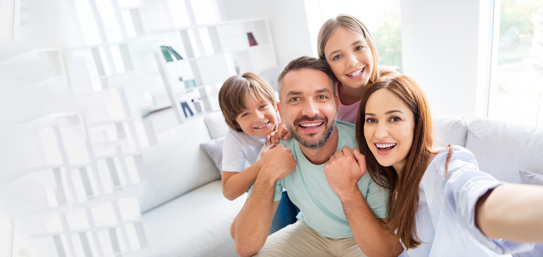 A family posing for a photo in front of a modern home.