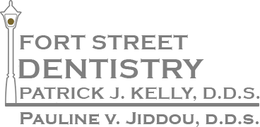 The image is a logo or sign for  Fort Street Dental,  featuring the names of dental professionals including Dr. Patrick J. Kelly and Dr. Pauline V. Jodou, along with a stylized depiction of a toothbrush and a tooth.