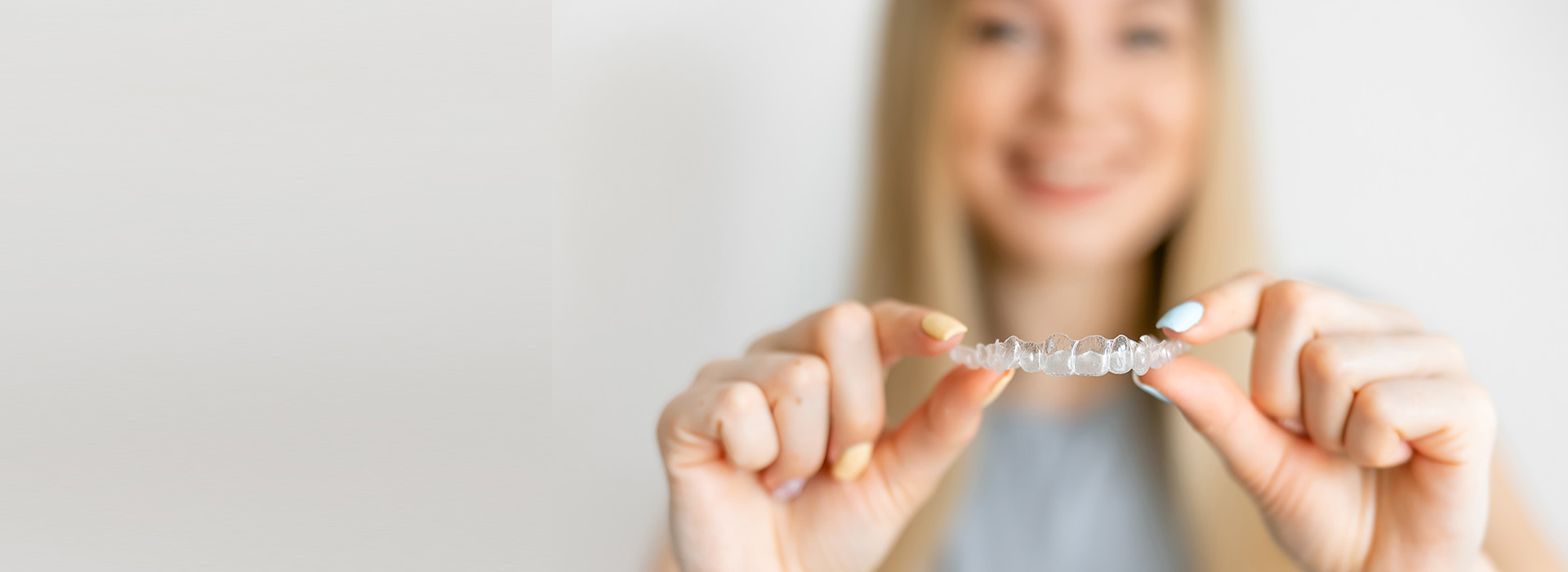 A woman holding a ring with her right hand against a blurred background.