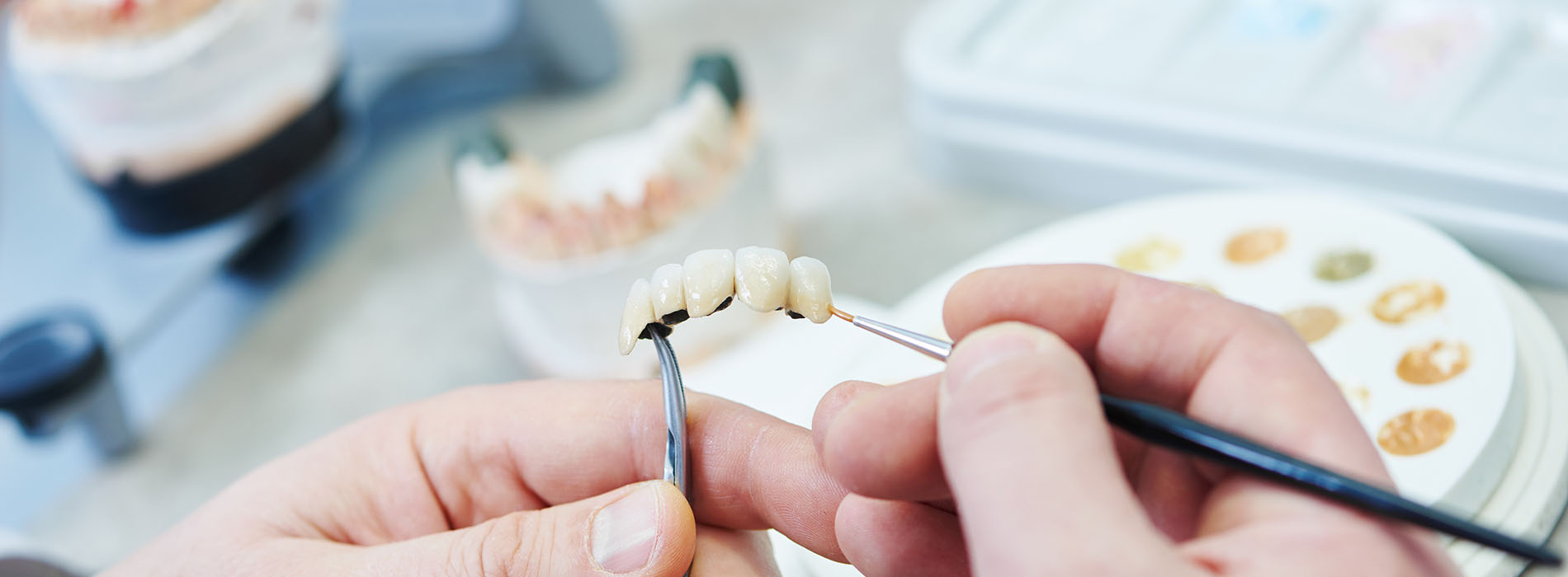 An individual is using a pair of tweezers to pick up a small object, possibly in the context of a craft or food preparation.